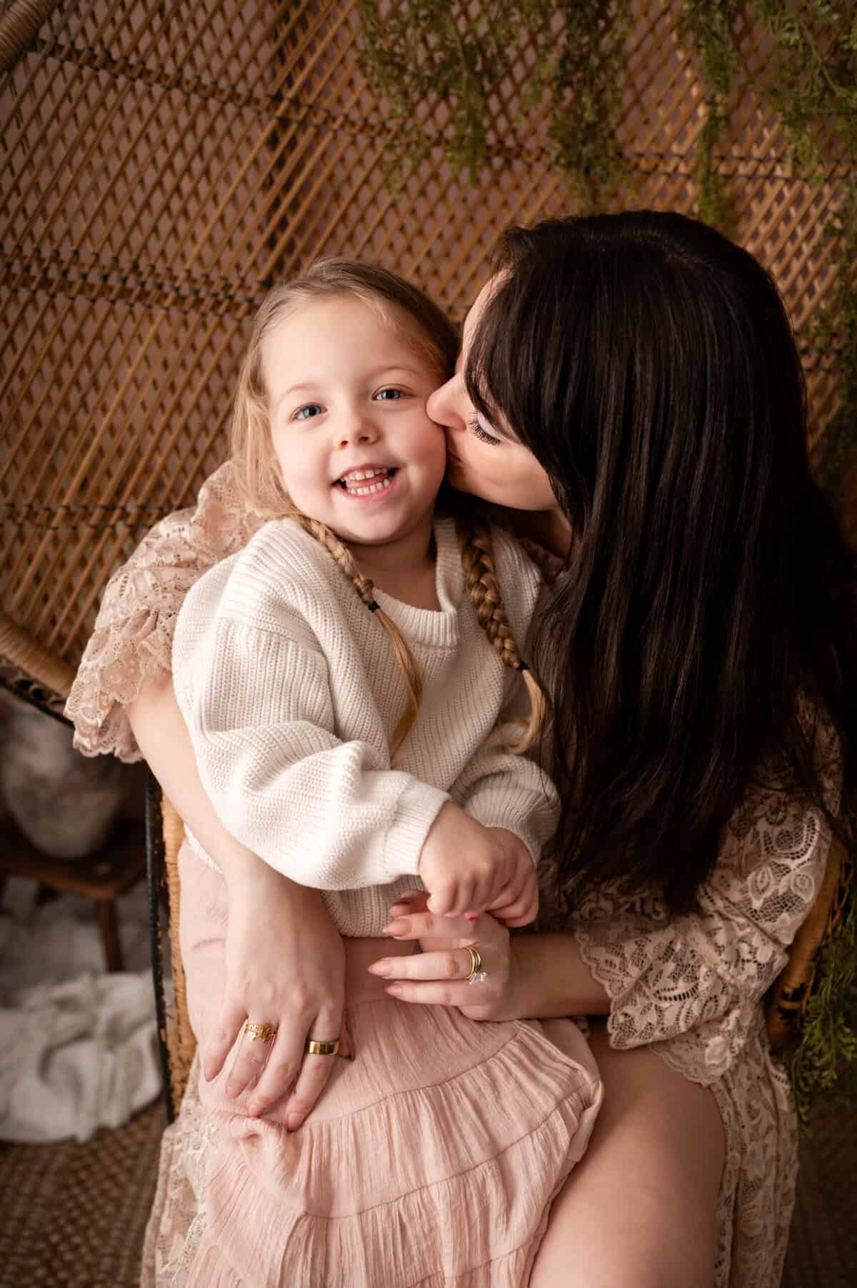 Wichita newborn photographer SJ Nuzum Photography shoots with a mother and her daughter on a peacock chair in client closet dresses