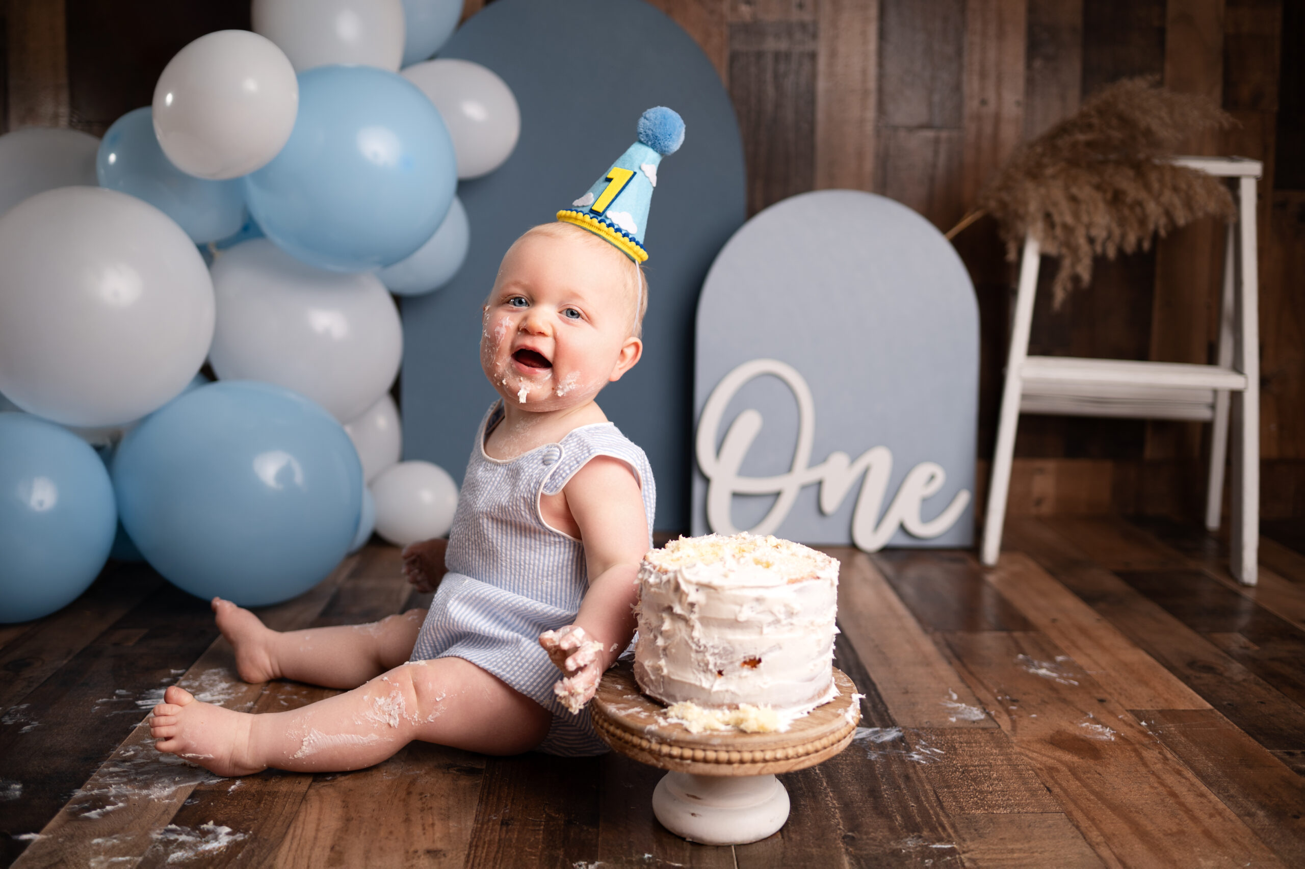 cake smash photo session blue balloons messy baby
