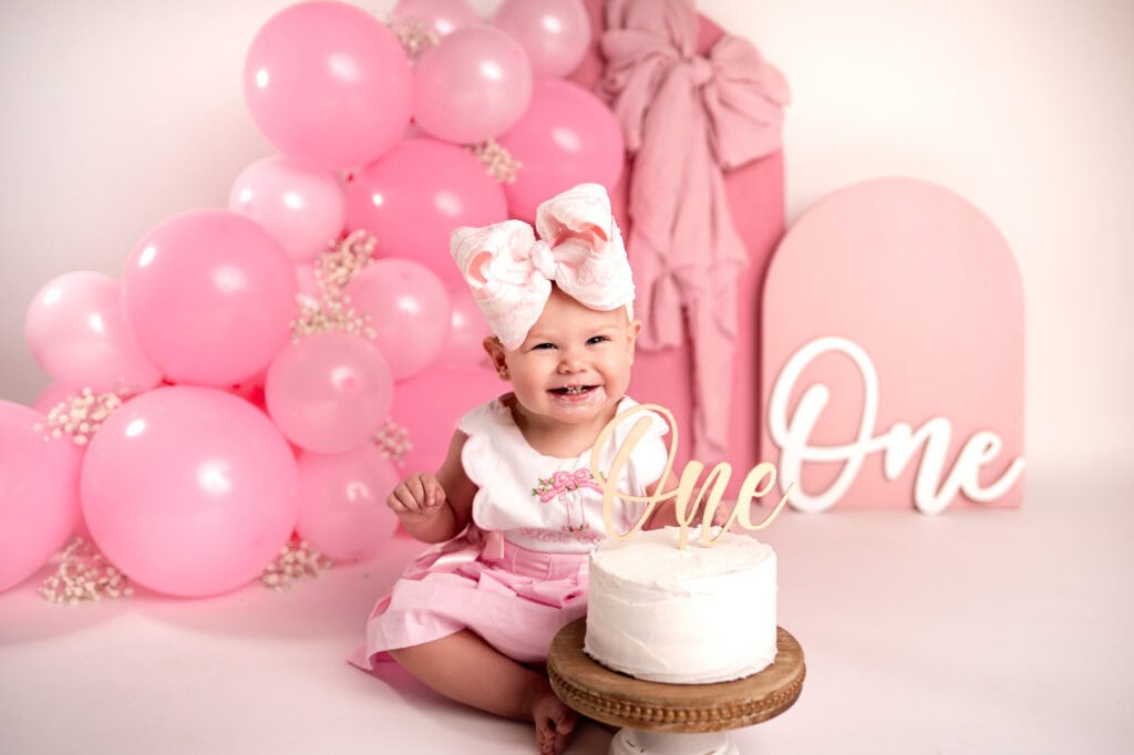 smash cake photographer birthday girl with cake smiles