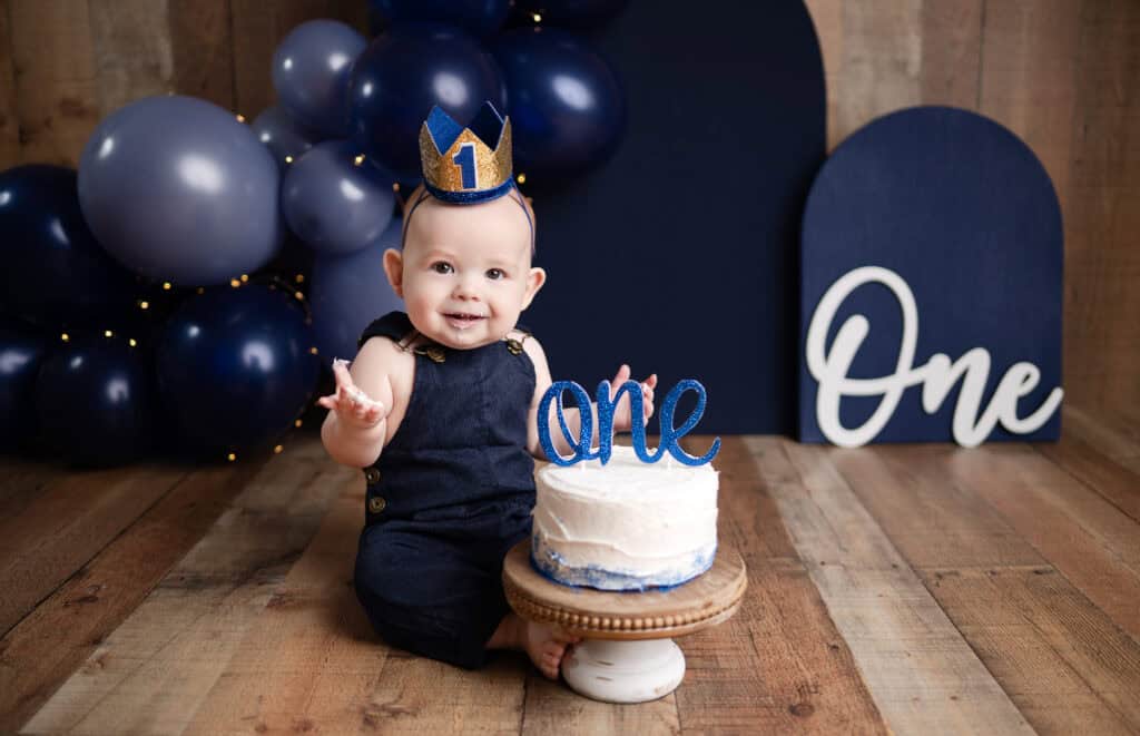 smash cake birthday boy in hat with cake photoshoot