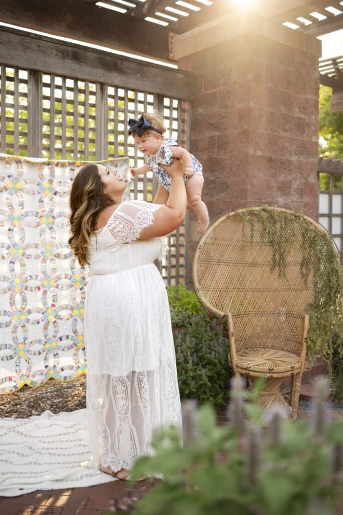 mother plays with baby girl at world breastfeeding week wichita ks sj nuzum photography